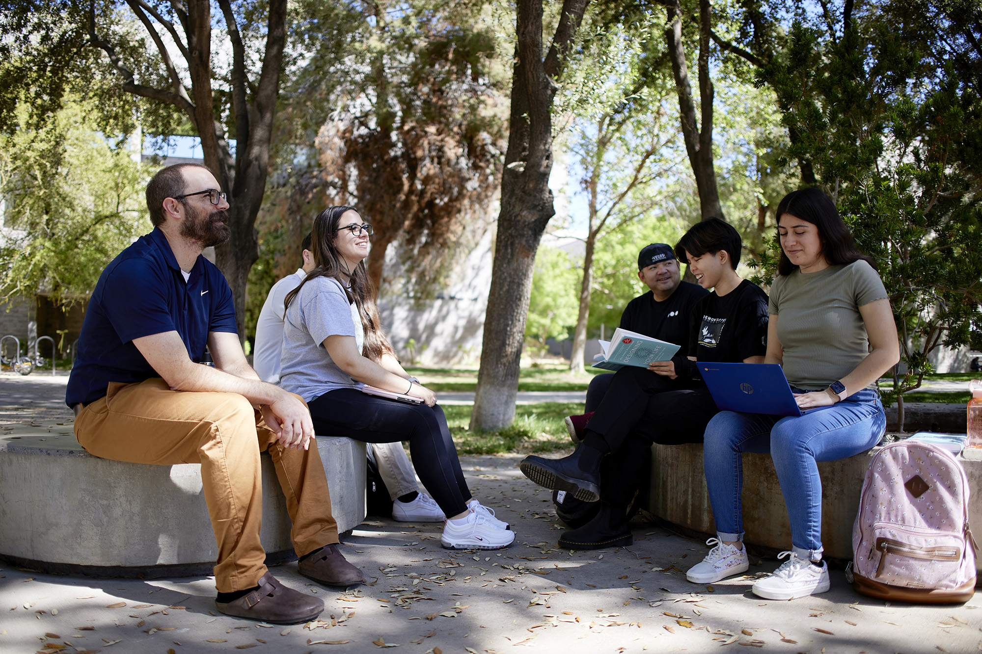 four people sitting outdoors in a park