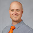 A man in a suit smiling.