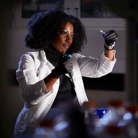 A woman in a lab conducting an experiment