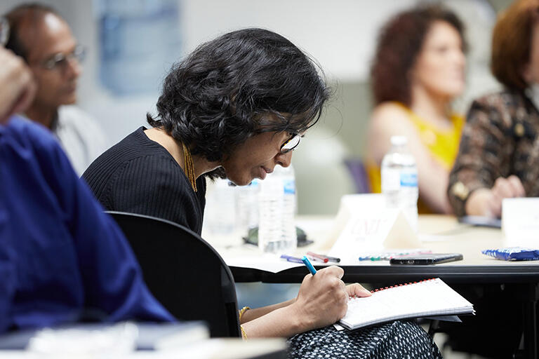 A woman writing on her notebook.