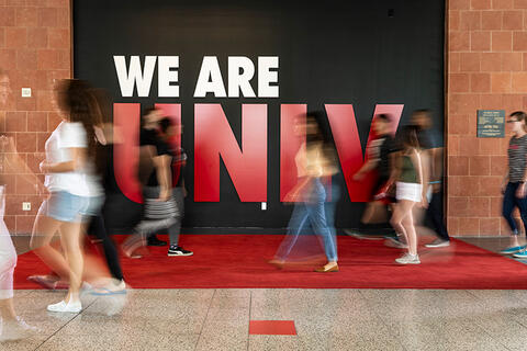 D72836-019.jpg Students walking in front of a sign that reads We Are U.N.L.V.