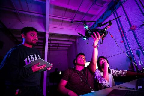OIT_20190726100157349_EDIT2.jpg Three students work with a drone
