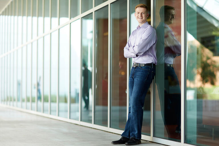 A man leans against a building