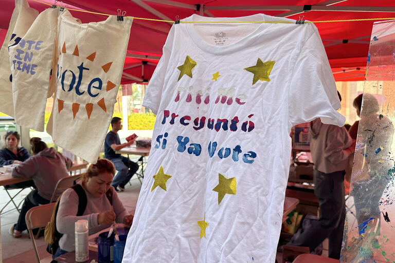 t-shirts with political statements hanging around a craft booth