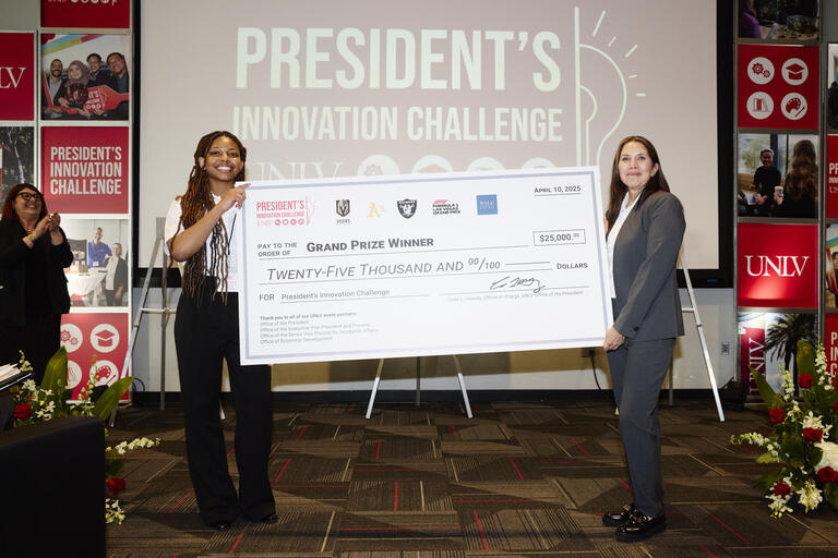 two women holding large grand prize check