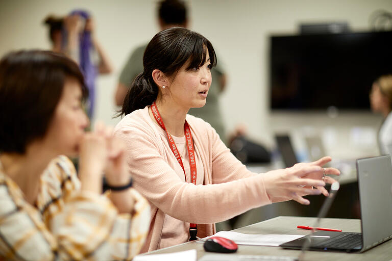 An instructor of World Languages and Cultures having a discussion with her peers.
